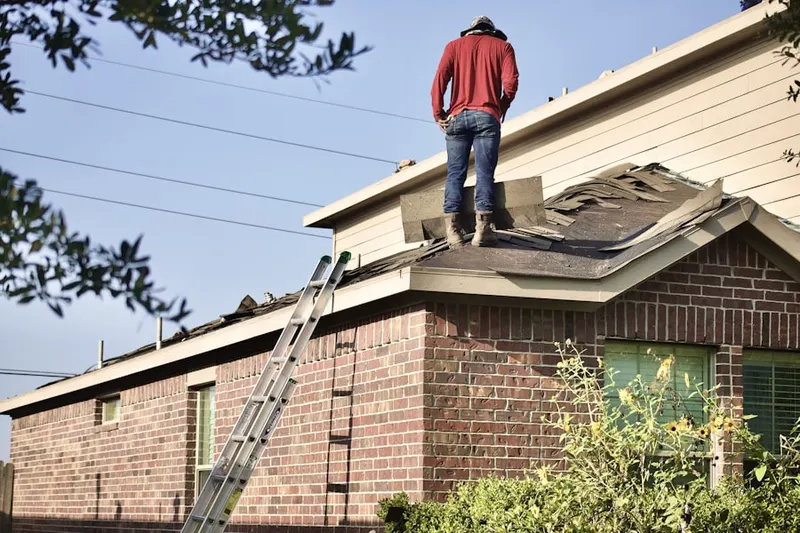Professional roofer working on a residential roof in Sprekelsville
